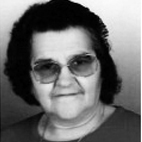 Retrato a preto e branco de uma mulher com óculos, a olhar para a câmara. Não há texto visível que permita identificá-la.