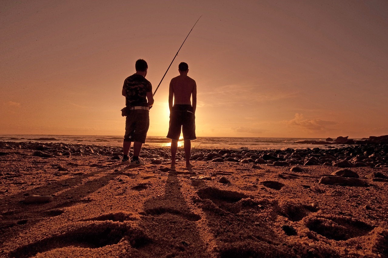 Dois jovens na praia a pescar