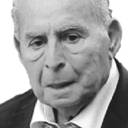 Retrato a preto e branco de um homem idoso, de fato e gravata, sobre um fundo claro.