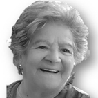 Retrato a preto e branco de uma mulher idosa, sorridente, com cabelo curto e grisalho. A imagem mostra o rosto e parte dos ombros sobre um fundo claro.