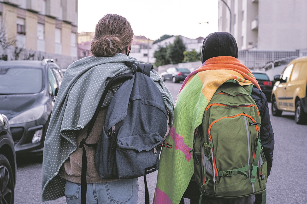 Dois alunos vão para a escola com mantas às costas para combater o frio