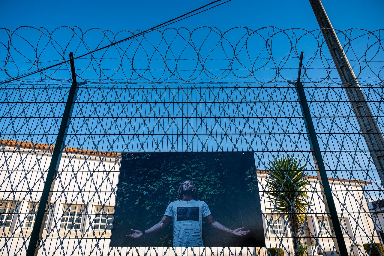 Fotografia do projeto Ópera na Prisão, colocada por detrás do gradeamento do estabelecimento prisional de leiria