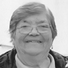 Retrato a preto e branco de uma mulher idosa, sorridente e com óculos. Não há texto visível que permita identificá-la.