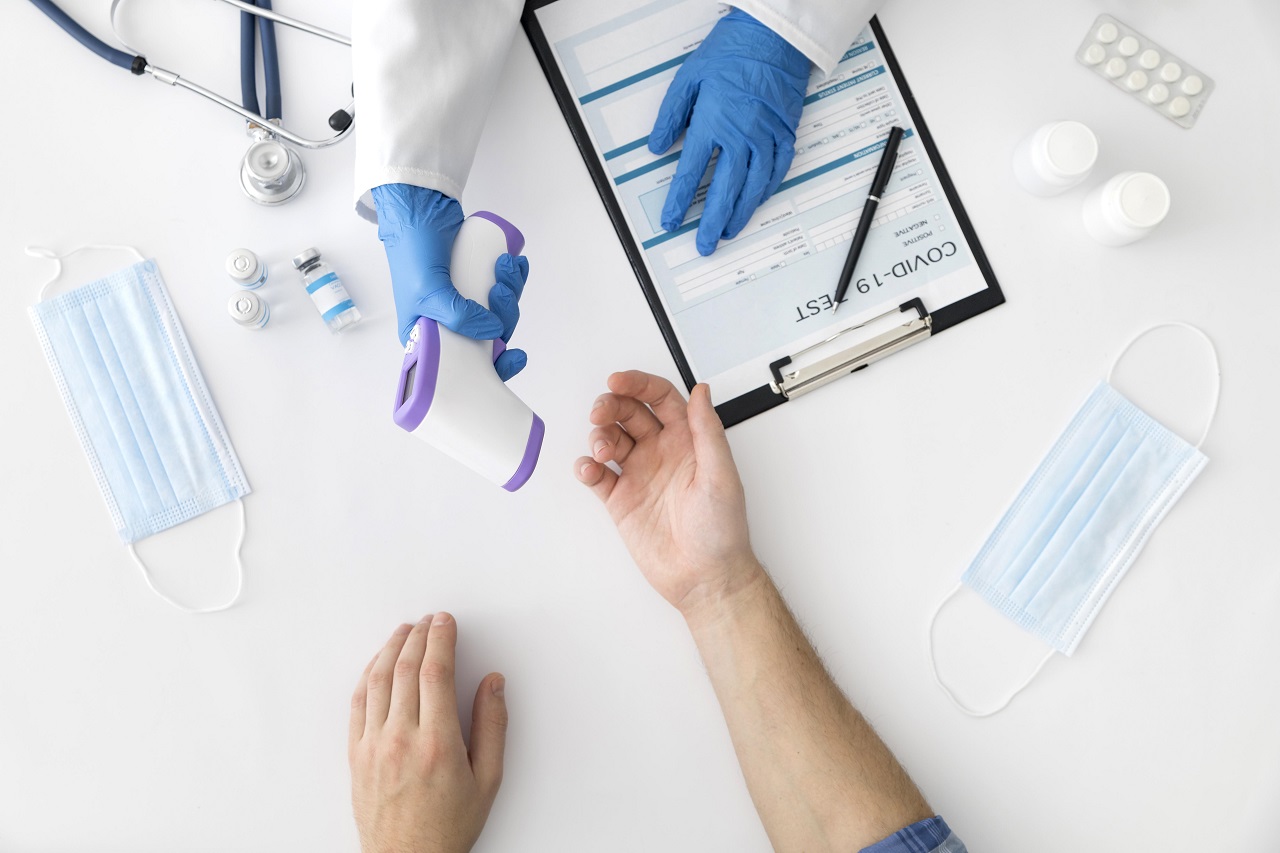 Vista superior do médico a medir a temperatura ao paciente