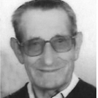 Retrato a preto e branco de um homem de óculos, vestido com fato e gravata. A imagem mostra apenas o rosto e a parte superior do tronco.