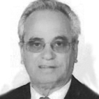 Retrato a preto e branco de um homem de fato e gravata, com óculos, sobre um fundo claro. A imagem não contém texto visível que permita identificá-lo.