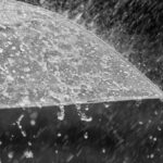 imagem de um chapéu de chuva aberto sob precipitação intensa