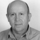 Retrato a preto e branco de um homem, fotografado de frente contra um fundo claro. Não há texto visível que permita identificá-lo.
