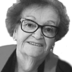 Retrato a preto e branco de uma mulher idosa com óculos, a sorrir para a câmara. A imagem não contém texto visível que permita identificá-la.