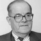 Retrato a preto e branco de um homem mais velho, de óculos, fato e gravata. Não há texto visível que permita identificá-lo.
