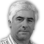 Retrato a preto e branco de um homem de cabelo grisalho, com uma camisola às riscas. Não há texto visível que permita identificá-lo.