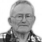 Retrato a preto e branco de um homem idoso, de frente para a câmara, com óculos e camisola aos quadrados. Não há texto visível que permita identificá-lo.