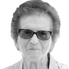Retrato a preto e branco de uma pessoa de cabelo curto e óculos escuros, fotografada de frente sobre um fundo claro. Não há texto visível que permita identificá-la.