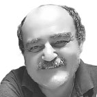 Fotografia a preto e branco de um homem sorridente, com bigode e pouco cabelo. O retrato mostra o rosto e parte dos ombros.