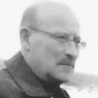 Retrato de um homem de óculos, visto de perfil, com uma paisagem desfocada ao fundo. Não há texto visível que permita identificá-lo.
