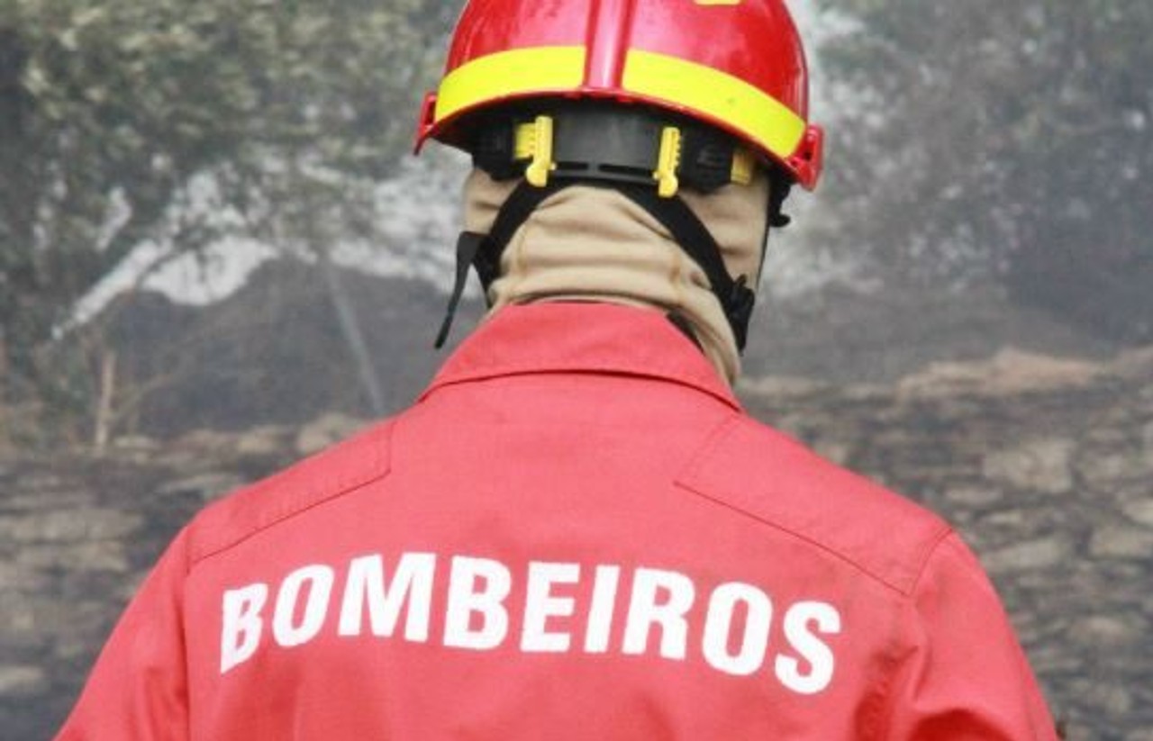 foto de bombeiro de costas em cenário de incêndio