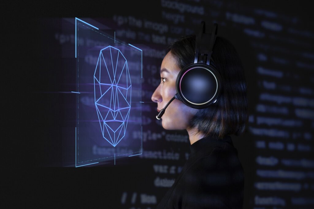 Uma pessoa com auscultadores e microfone observa uma representação digital de um rosto formada por linhas geométricas. A imagem sugere o tema do reconhecimento facial, mas não mostra uma identificação concluída.