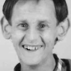 Retrato a preto e branco de uma pessoa sorridente, fotografada de frente. Não há texto visível que permita identificá-la.