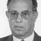 Retrato a preto e branco de um homem de fato, gravata e óculos. Não há texto visível que permita identificá-lo.