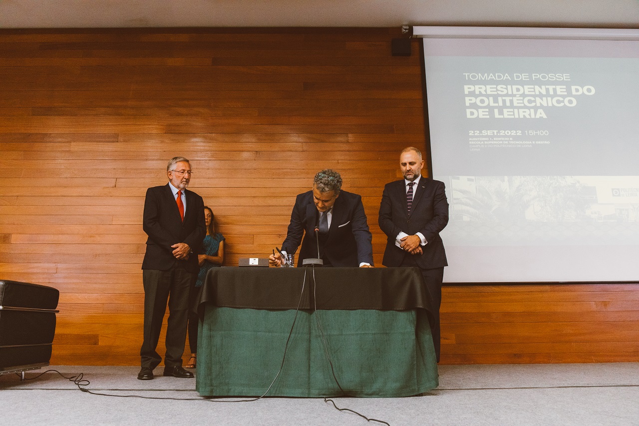 Foto de Carlos rabadão a assinar tomada de posse ladeado por Pedro Lourtie e Rui Pedrosa
