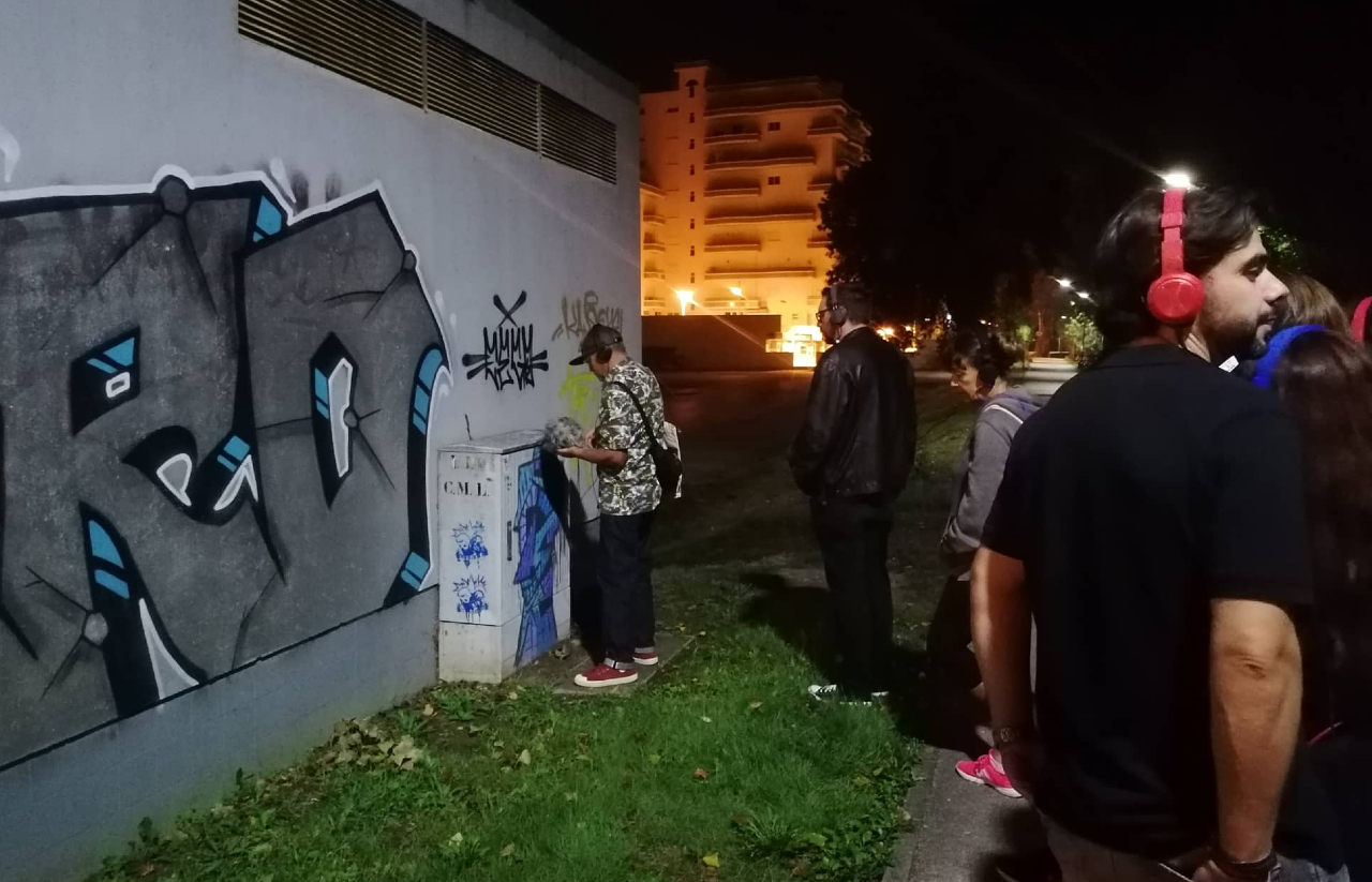 grupo de pessoas de auscultadores na rua à noite