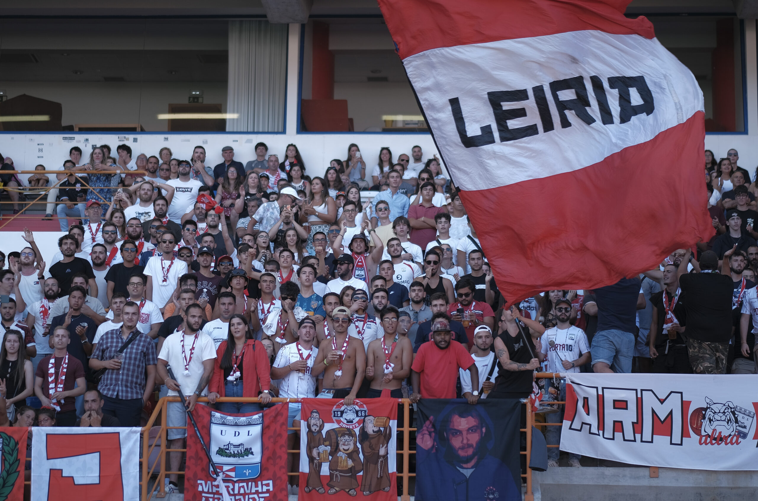 foto de uma bancada do estádio dr. magalhães pessoa com adeptos da união de leiria e bandeiras do clube