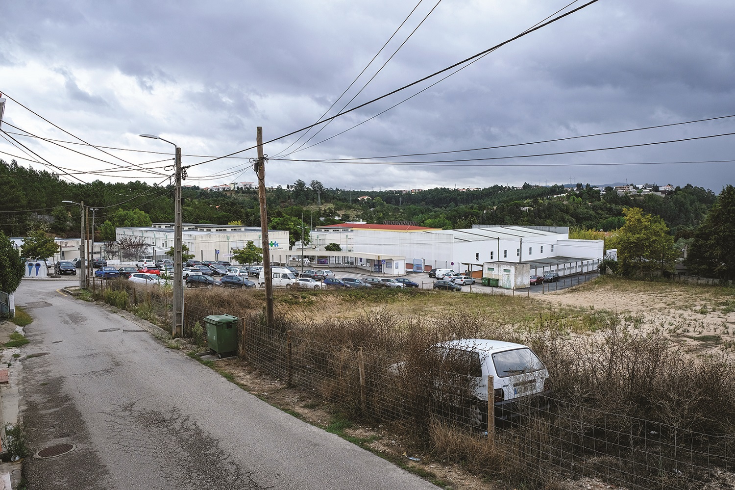 Vista da rua São Luís com a escola Dr. Correia Mateus e respetivo parque de estacionamentoao fundo