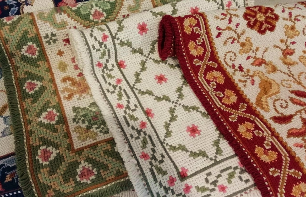 vários tapetes de arraiolos em monte