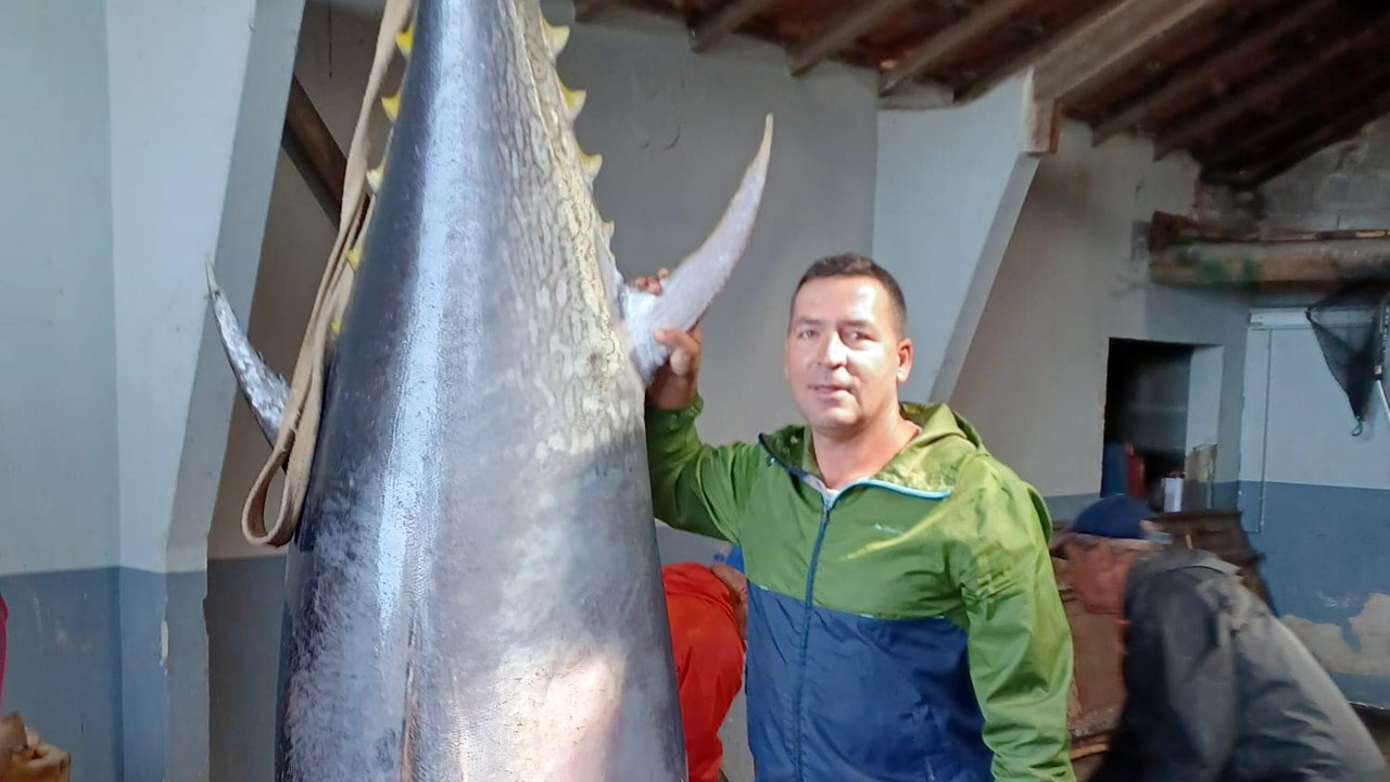 Foto do pescador Daniel Nunes ao lado do atum de mais de dois metros