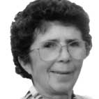 Retrato a preto e branco de uma pessoa com cabelo curto e óculos, enquadrada de frente. Não há texto visível que permita identificá-la.