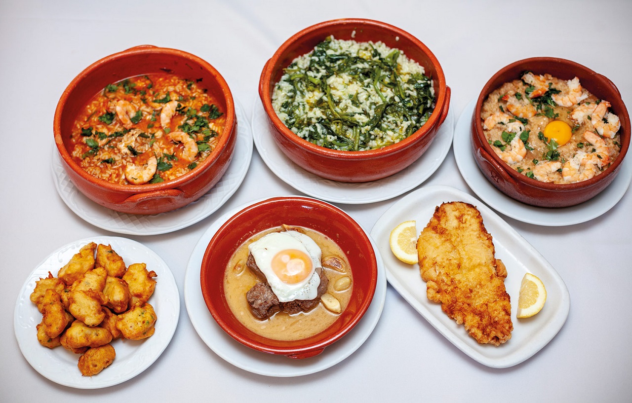 for de mesa com tachos de barro com vários petiscos de carne, peixe e marisco