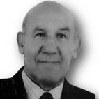 Retrato a preto e branco de um homem de fato e gravata, fotografado de frente sobre um fundo claro. Não há texto visível que permita identificá-lo.