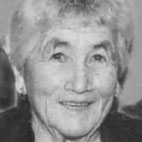 Retrato a preto e branco de uma mulher idosa, fotografada de frente e a sorrir. Não há texto visível que permita identificá-la.