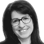 Retrato a preto e branco de uma mulher sorridente, com cabelo escuro e óculos, sobre um fundo claro. Não há texto visível que permita identificá-la.