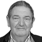 Retrato a preto e branco de um homem, fotografado de frente sobre um fundo claro. Não há texto visível que permita identificá-lo.