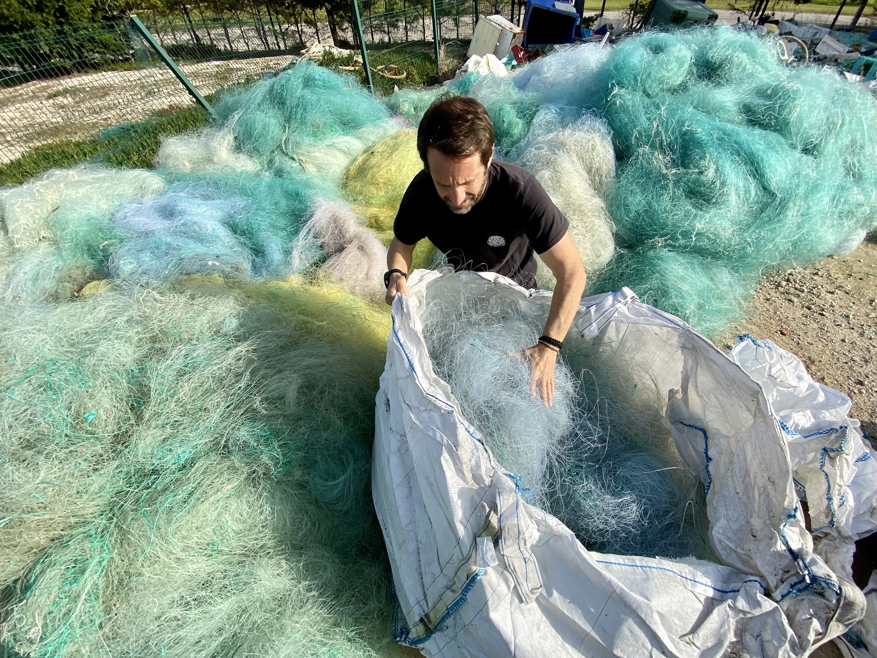 foto de homem a recolher redes de pesca