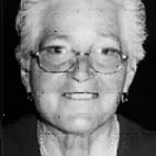 Retrato a preto e branco de uma mulher idosa com óculos, voltada para a câmara. Não há texto visível que permita identificá-la.