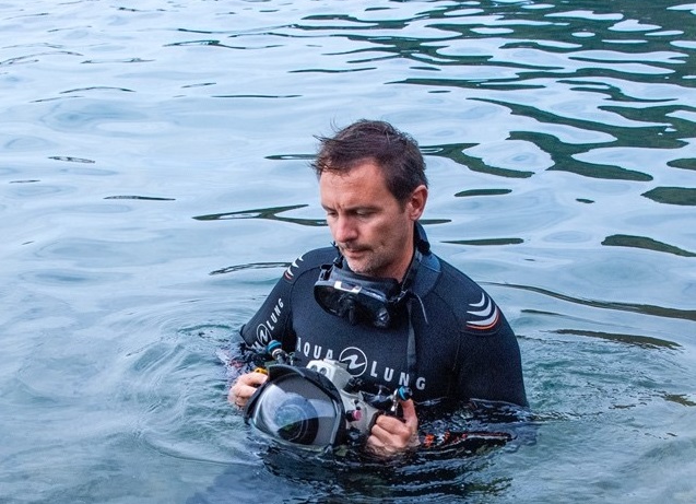 foto de nuno vasco rodrigues no mar com fato de mergulho e máquina fotográfica.