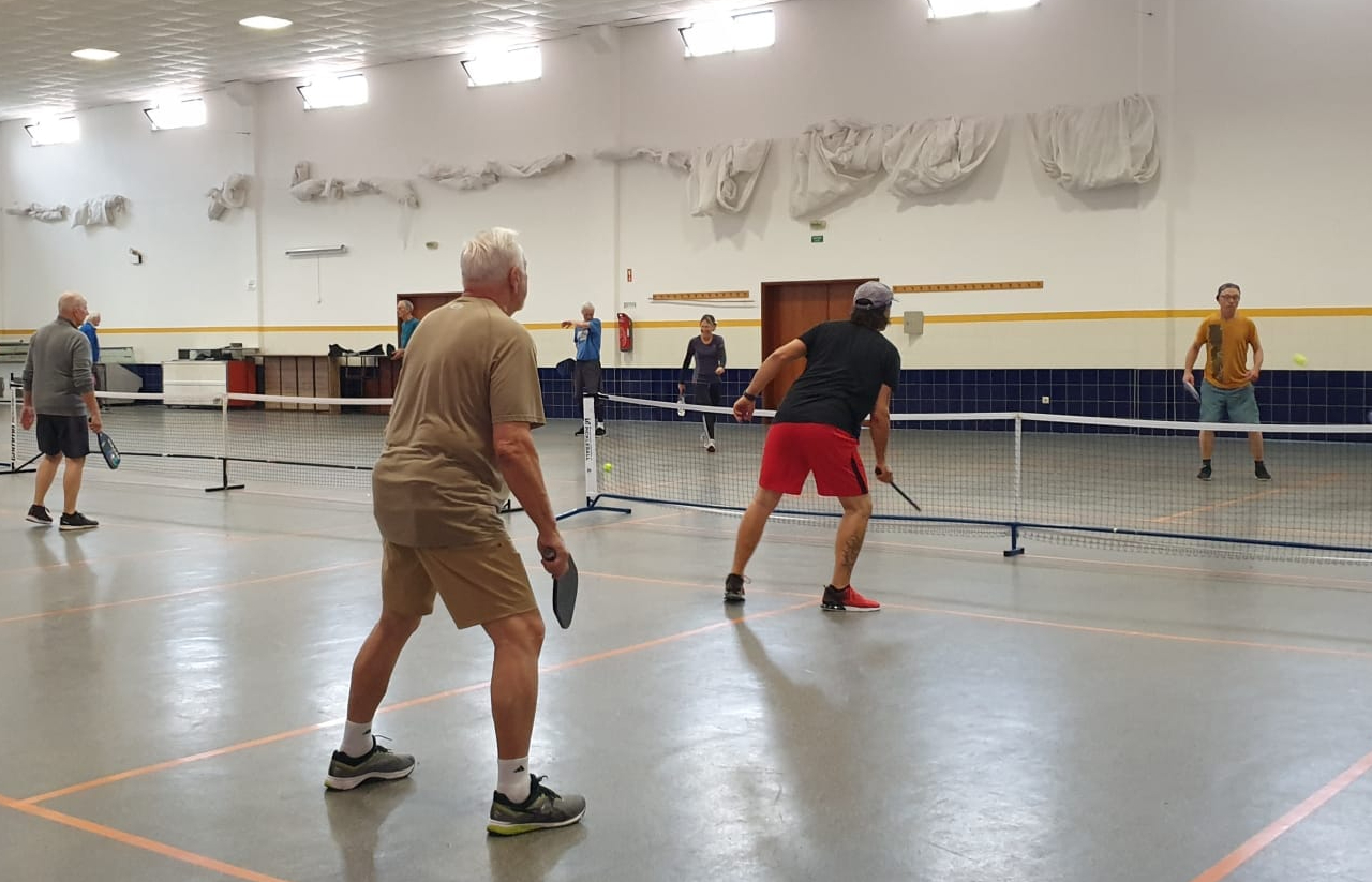 várias pessoas a jogar pickleball, uma modalidade que mistura ténis e badminton