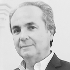 Retrato a preto e branco de um homem de cabelo grisalho, com camisola e casaco. Não há texto visível que permita identificá-lo.