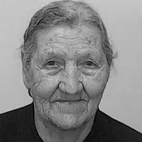 Retrato a preto e branco de uma pessoa idosa, de frente para a câmara, com expressão serena. O fundo é liso e não há texto visível que permita identificá-la.
