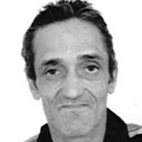 Retrato a preto e branco de um homem, fotografado de frente, com fundo claro. Não há texto visível que permita identificá-lo.