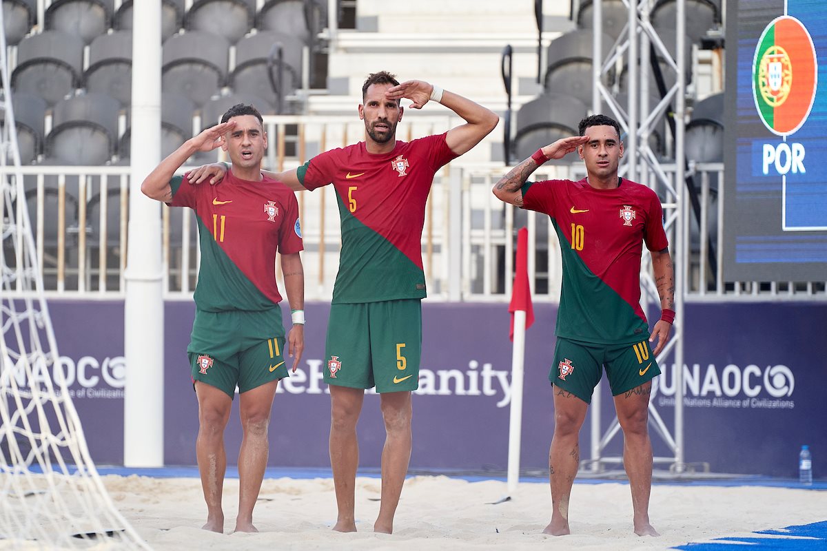 três jogadores da seleção nacional de futebol de praia a fazer continência