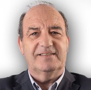 Retrato de um homem de meia-idade, de frente para a câmara, com casaco escuro e camisola clara. O fundo é branco e não há texto visível que permita identificá-lo.