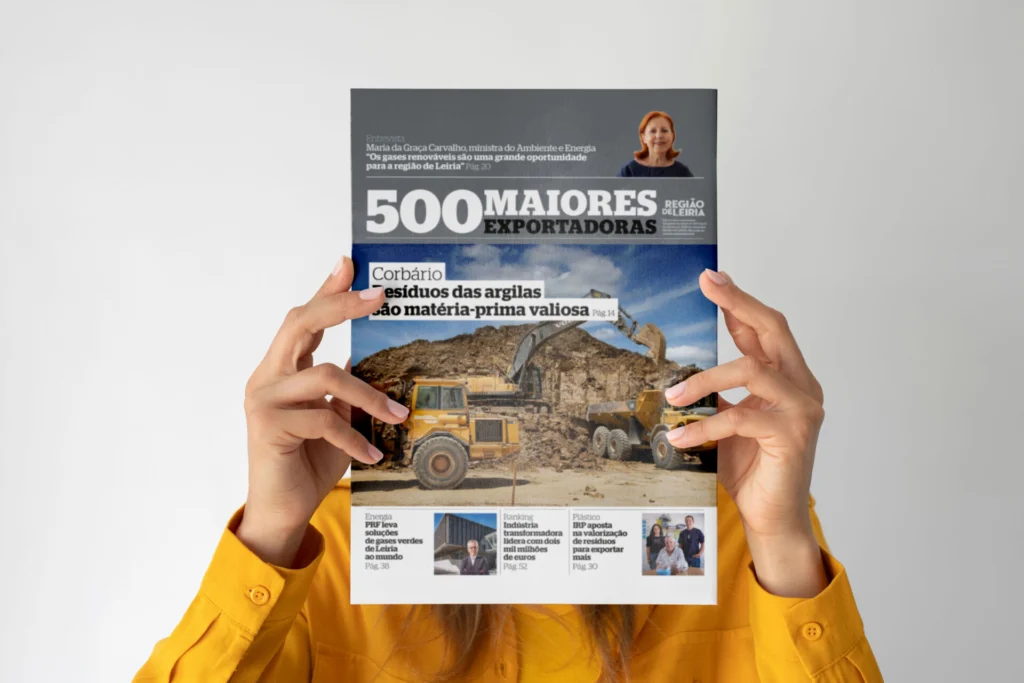Uma pessoa segura uma publicação sobre as 500 maiores exportadoras da região de Leiria. A capa destaca o aproveitamento de resíduos das argilas e uma entrevista sobre gases renováveis.
