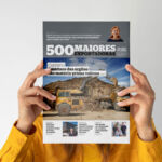 Uma pessoa segura uma publicação sobre as 500 maiores exportadoras da região de Leiria. A capa destaca o aproveitamento de resíduos das argilas e uma entrevista sobre gases renováveis.