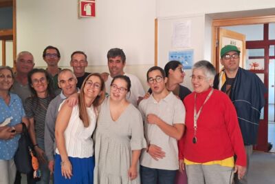 Um grupo de pessoas posa para uma fotografia no interior de um edifício. Ao fundo, vê-se uma porta aberta com a indicação «SALA D».