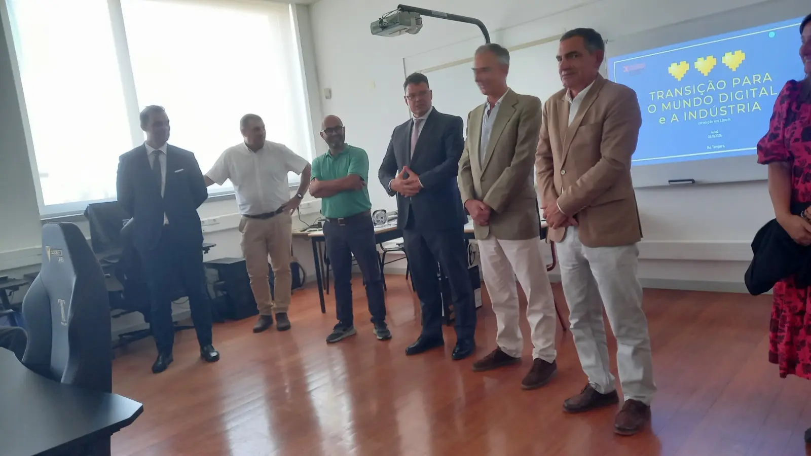 Um grupo de pessoas está reunido numa sala de formação, junto a uma apresentação projetada com o título «Transição para o Mundo Digital e a Indústria». São visíveis computadores e um projetor.