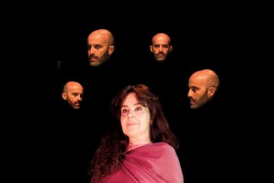 Uma mulher com um tecido cor-de-rosa ocupa o primeiro plano sobre um fundo preto. À sua volta surgem quatro imagens do rosto de um homem careca e com barba.